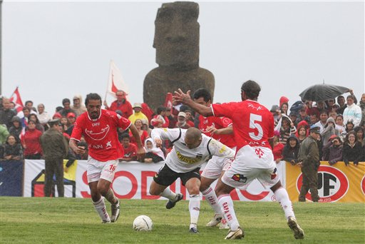 Cristian Bogado, center, of Chile's Colo Colo, fights for the ball with players of the Easter Island amateur team Rapa Nui during a soccer match that makes up part of the Copa Chile tournament in Easter Island, Wednesday, Aug. 5, 2009. (AP Photo/Marco Muga)
